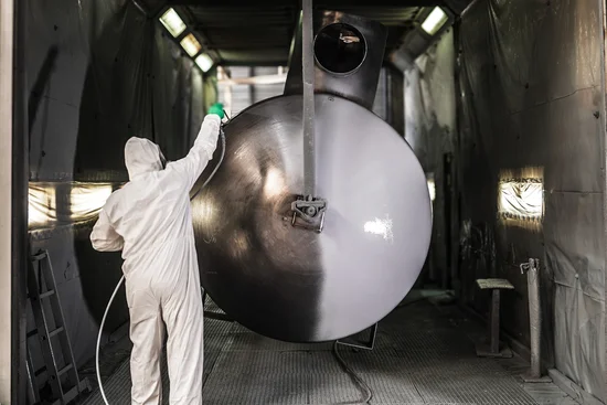 Photo d'un peintre industriel appliquant un revêtement époxy lutant contre la rouille sur la cuve - Chaudreau